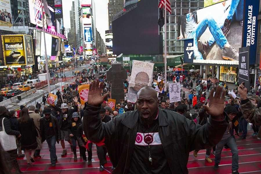 A man leads the Oct. 22 Day of National Protest up the steps in Times Square.