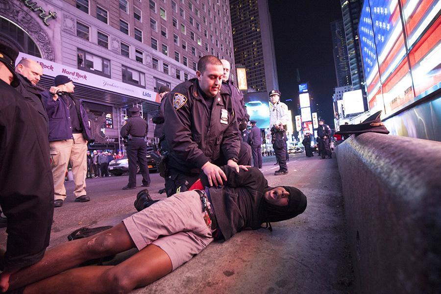 A demonstrator is restrained by police in Times Square.
