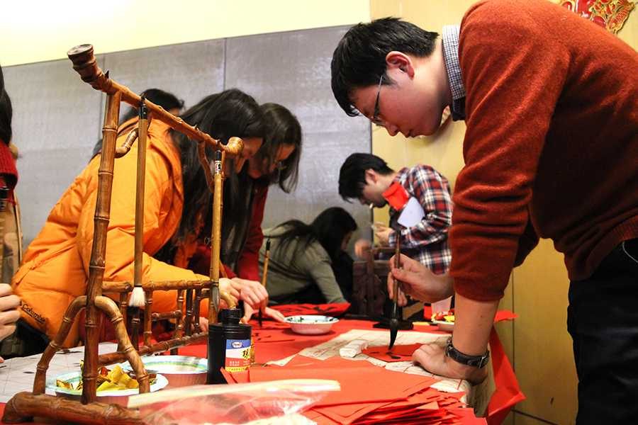 Wu+Ke+helps+students+practice+their+calligraphy+during+the+Chinese+New+Year+event.