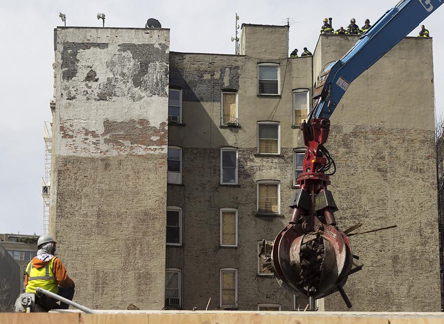 Construction workers cleanup damage from the East Village fire.
