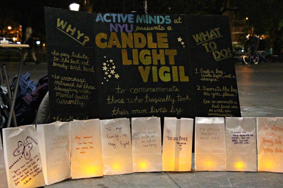 Posters and words of commemoration and encouragement as part of a candlelight vigil for those who have committed suicide.