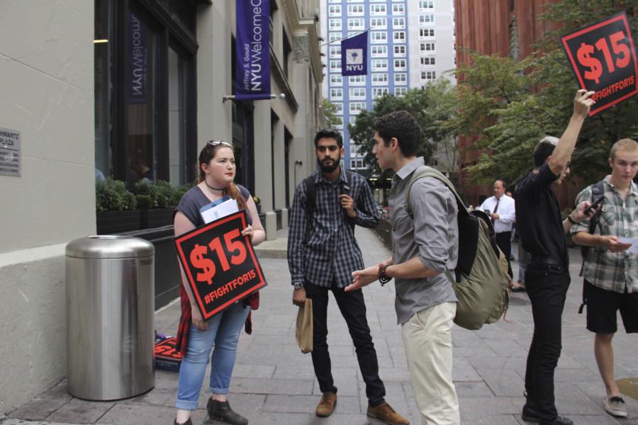 Haley Quinn (left) and Vishnu Bachani (center) of NYU’s Student Labor Action Movement speak to prospective student Elliot Waxman (right) about raising student worker pay to $15 an hour in front of the NYU Welcome Center on Friday, Oct. 9, 2015.