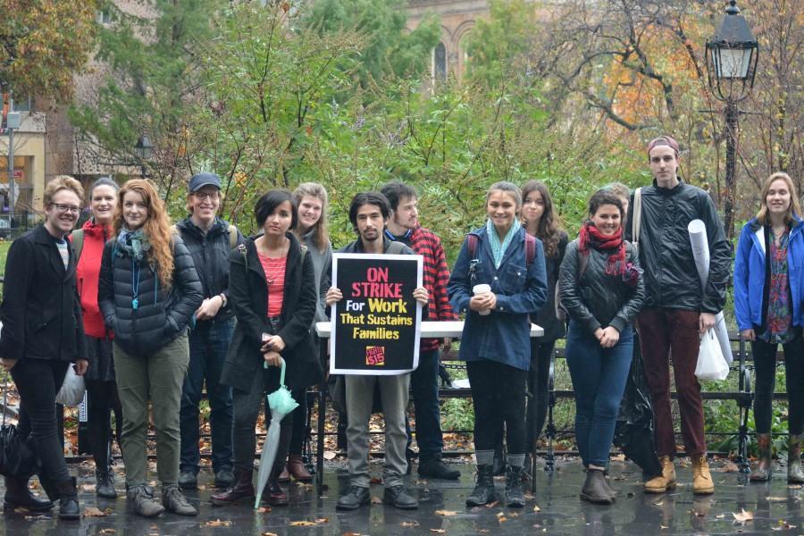 Braving the rain, students gather in Washington Square Park to protest wages provided by NYU for their student employees. 