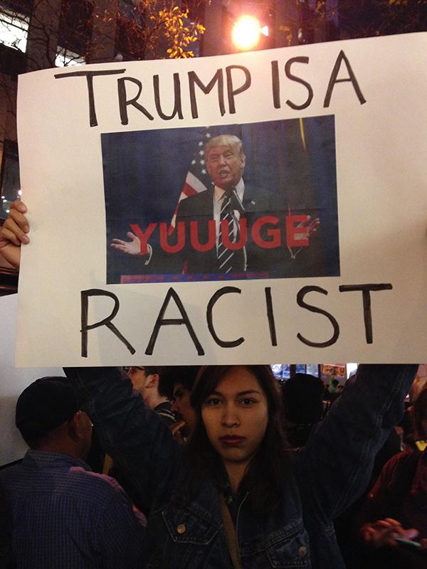 NYU Dream Team protester holds a sign at 30 Rockefeller Center in retaliation to Donald Trump’s appearance on Saturday Night Live.