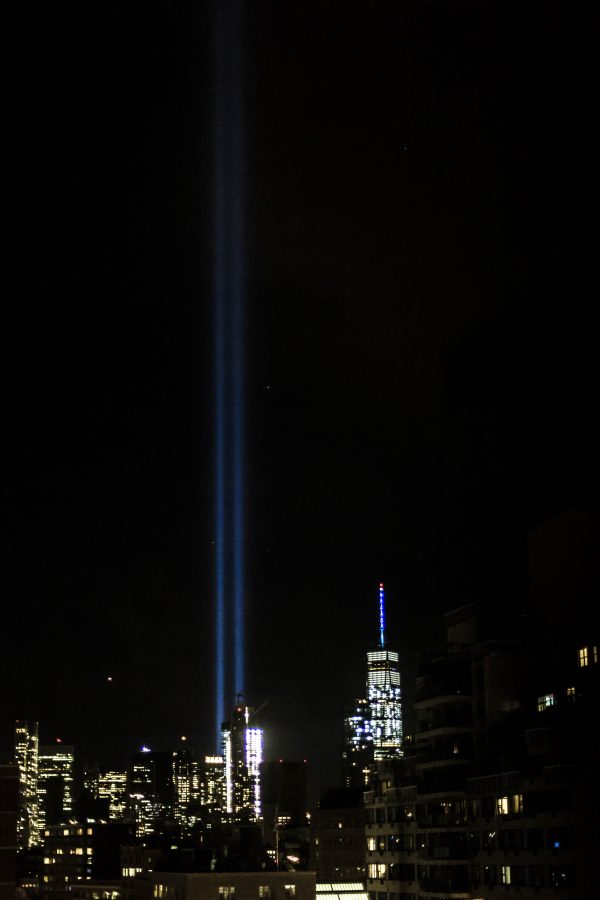 Two bright beams shine from the 9/11 Memorial’s reflecting pools, marking the sky with a ghost of where the Twin Towers once stood. 