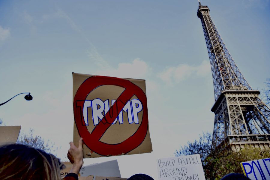 A protester raises her anti-Trump sign near the Eiffel Tower during a rally on Saturday.