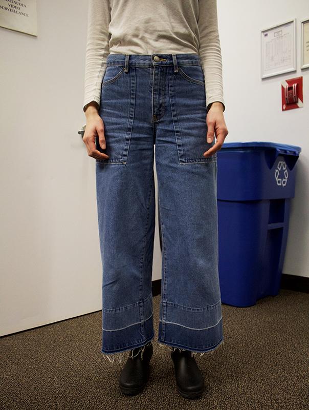 This pair of wide leg jeans is paired with a light colored top and short, black rainboots for an effortless, put together look. The high waisted style extends the legs.
