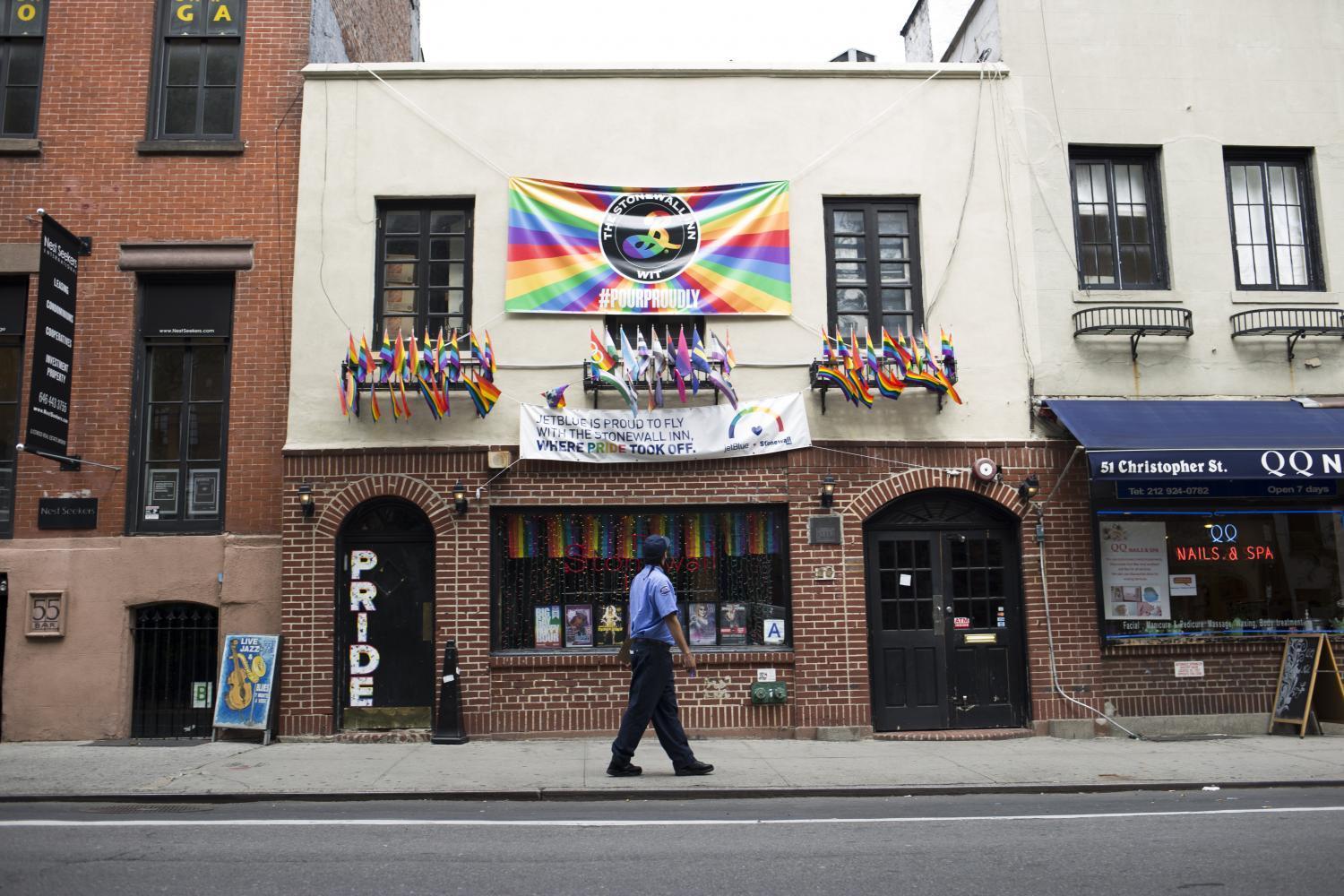 A man slowly walks past Stonewall Inn, examining its front.
