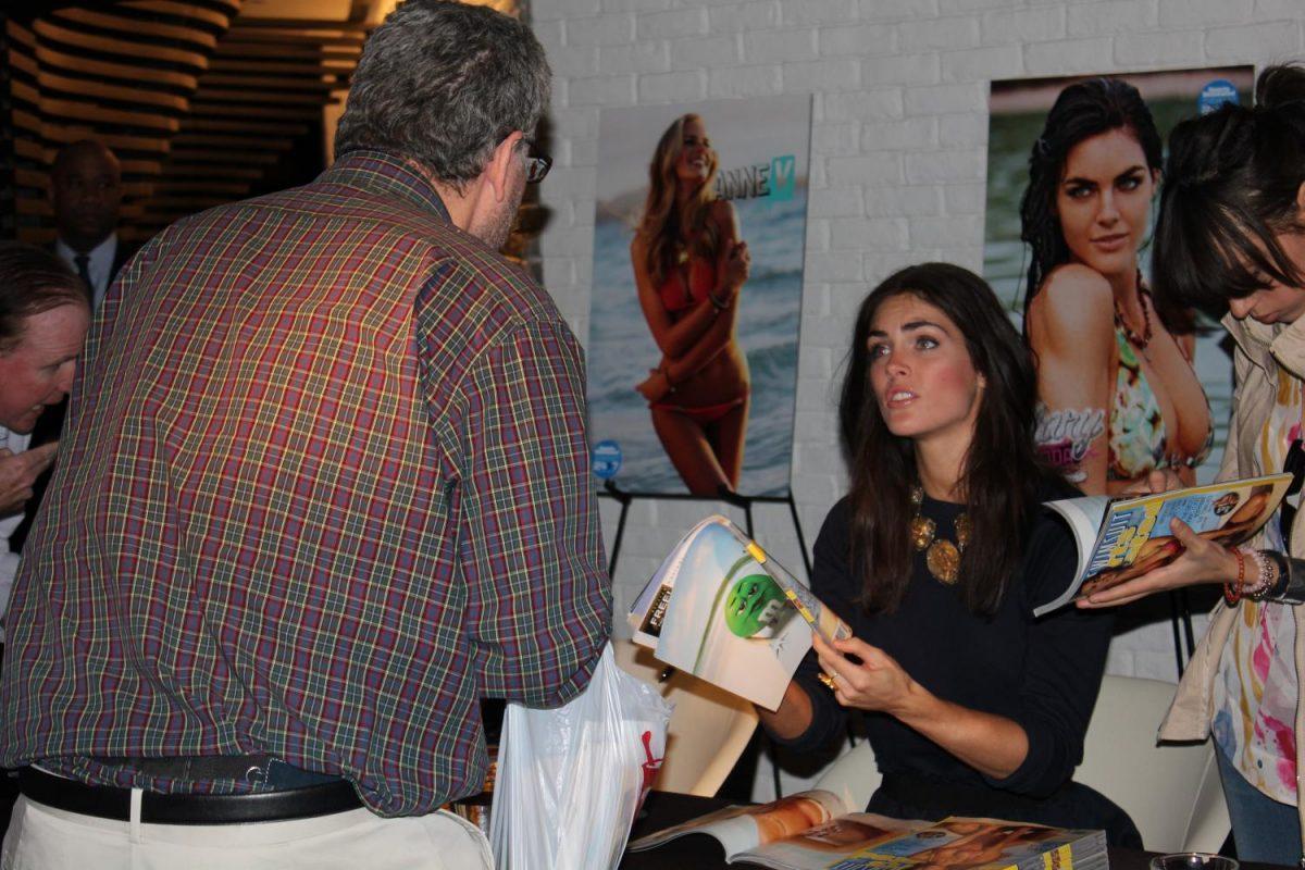 Model Hilary Rhoda signs a copy of the yearly Sports Illustrated swimsuit issue for a man at the Cosmopolitan of Las Vegas. Many people feel this issue promotes sexual objectification.
