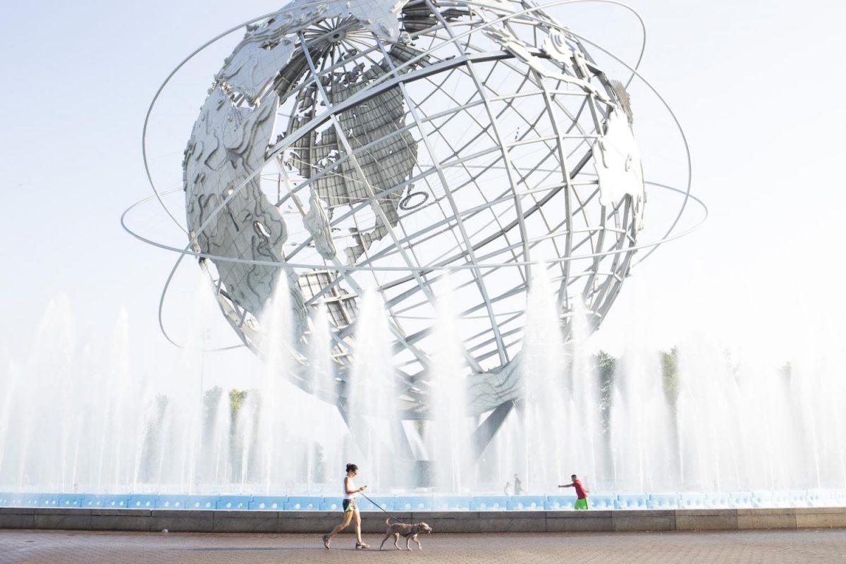 A woman walks her dog past the Unisphere in Flushing-Meadows Corona Park in the borough of Queens.