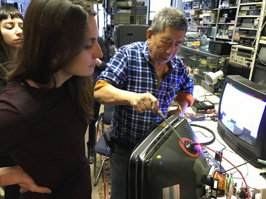 NYU students Lia Kramer and Joy Bloser during a workshop at CTL Electronics, inspecting a Cathode Ray Tube monitor.
