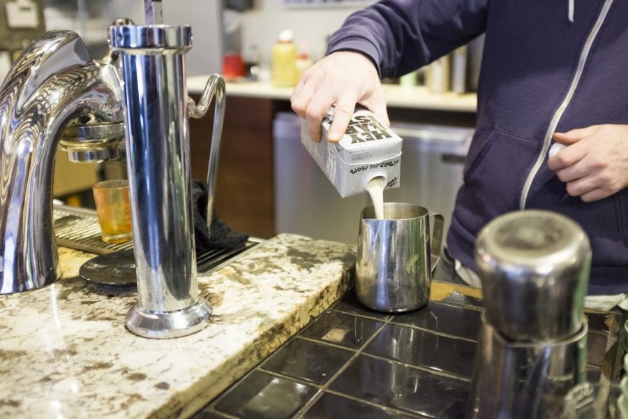 A barista pours Oatly oat milk at City of Saints on Astor Place.