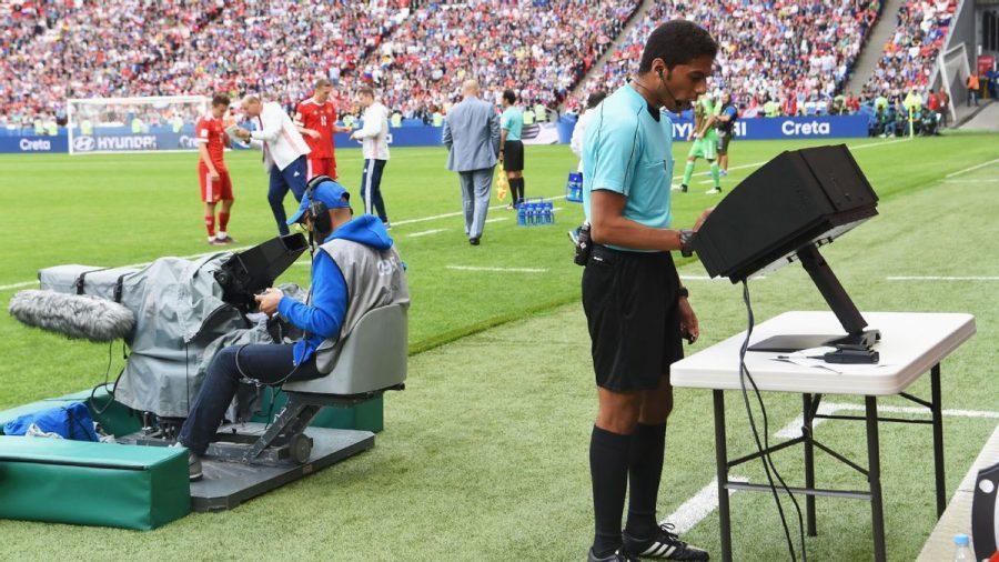 A referee uses VAR to make a call during a game.