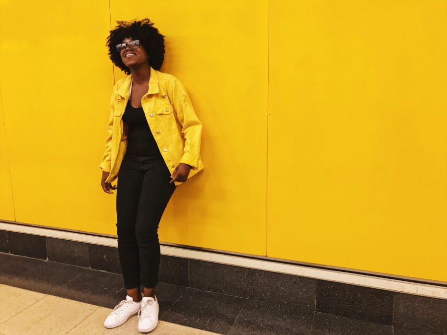 NYU Madrid student Laurie Germain beside the iconic yellow walls of the Madrid  metro.