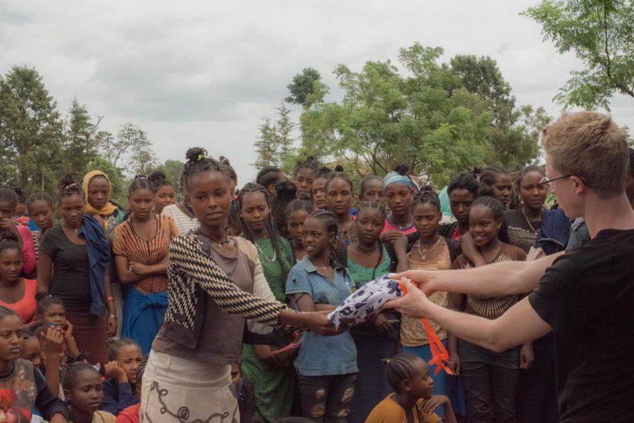 Director of Coffee and International Projects for Think Noah Welch distributing menstrual kits in Kellensoo, Ethiopia.