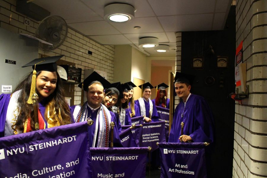 Class representatives hold their flags as they wait to walk on to stage.