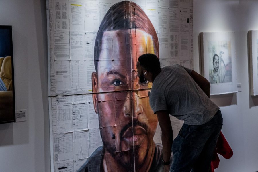 In the Museum of Broken Windows, a man looks at a painting made from seven years of the artist’s criminal justice paperwork.