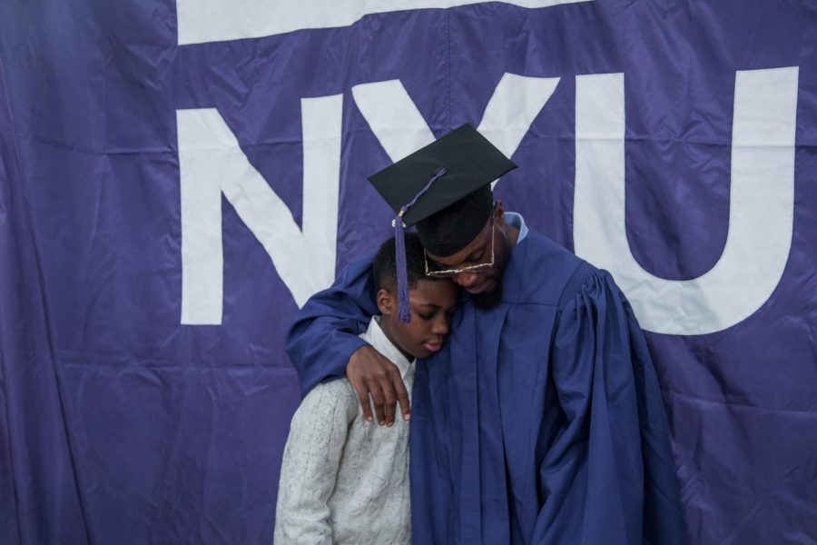 Jermaine Haywood with his son, Jermaine Jr., after receiving his diploma through NYU's Prison Education Program. (Photo by Sam Klein)