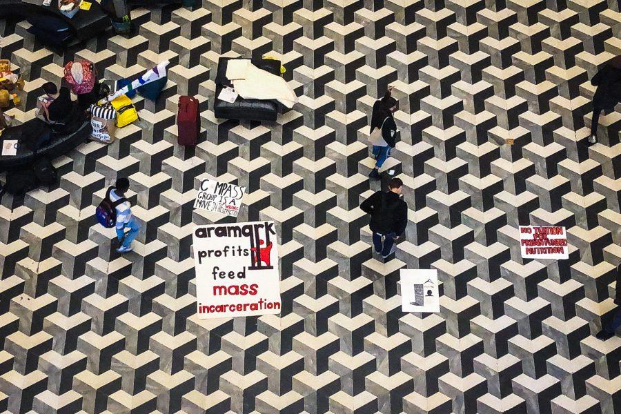 Signs protesting against Aramark, one of NYUs current dining service providers, are placed on the floor of Bobst Library atrium since Monday. (Photo by Tony Wu)
