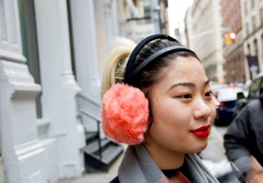 A woman wears coral earmuffs in the streets of SoHo, New York. (Photo by Jorene He)