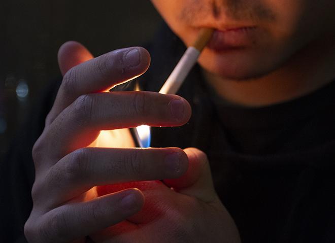 An NYU student lights a cigarette. (Photo by Cydney Blitzer)