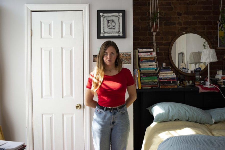 Cora Lee Womble-Miesner stands in front of the exposed brick walls in her bedroom filled with books and other trinkets. She says theres a clear wealth divide at NYU in terms of how and where students live. (Photo by Katie Peurrung)