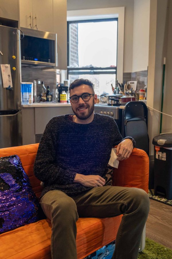 Michael Marinaccio sits on his sofa in his apartment in Spanish Harlem. One day he hopes to move further downtown — preferably to a studio in Midtown. (Photo by Justin Park)