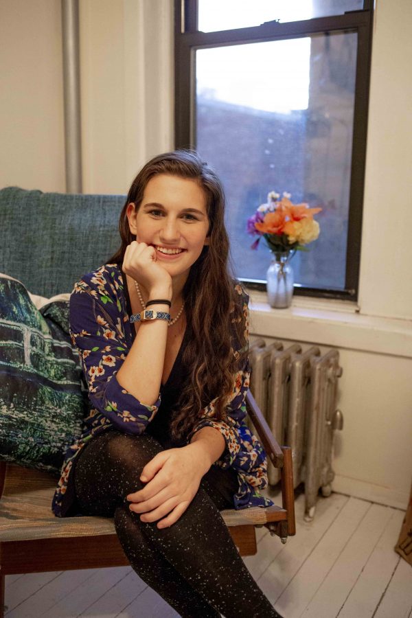 Sitting on her armchair right next to the window Rachel Arbacher shared her experience paying for her own rent. She lives with two of her roommates in the East Village. (Photo by Katie Peurrung)