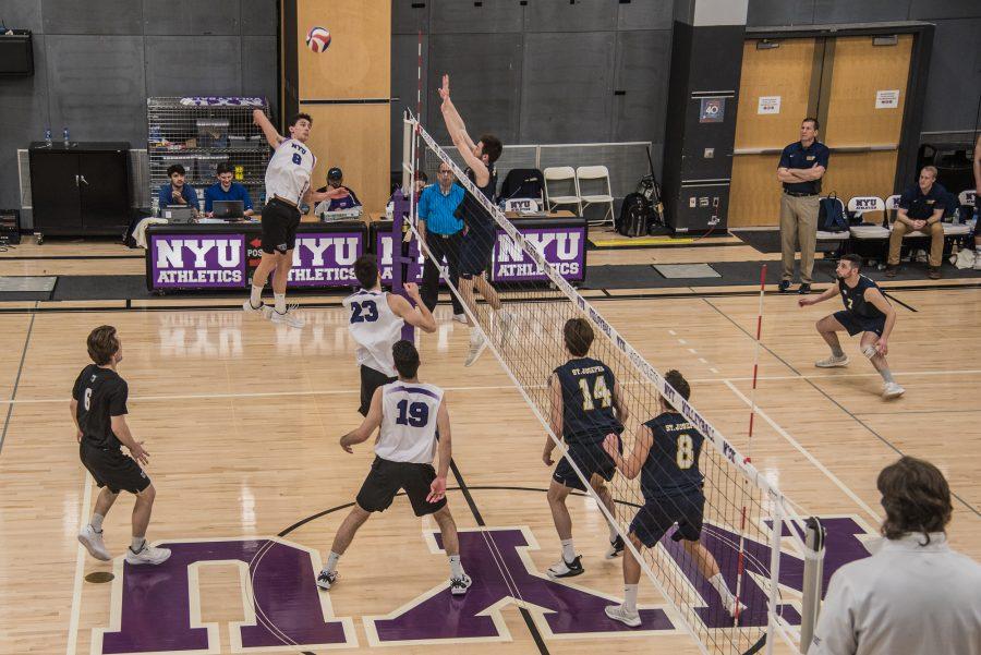 First-year James Haag (8) goes for a kill in a game against St. Joseph’s College (L.I.) on Saturday. NYU won the game in four sets, moving their record to 12-8 overall. (Photo by Sam Klein)