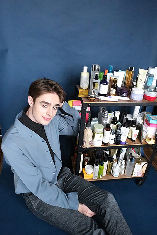 Neiley poses next to a shelf loaded with his favorite skincare products, many of which are Korean. (Photo by Jorene He)