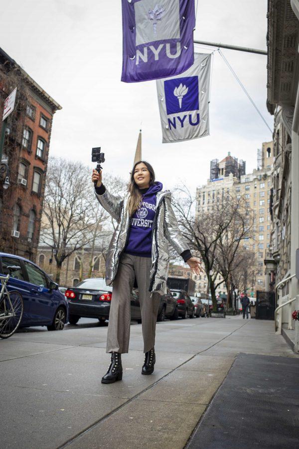 Kudaibergen vlogs outside of Steinhardts Barney building, decked out in NYU apparel. In recent months, her channel has primarily consisted of NYU-related content. (Photo by Katie Peurrung)