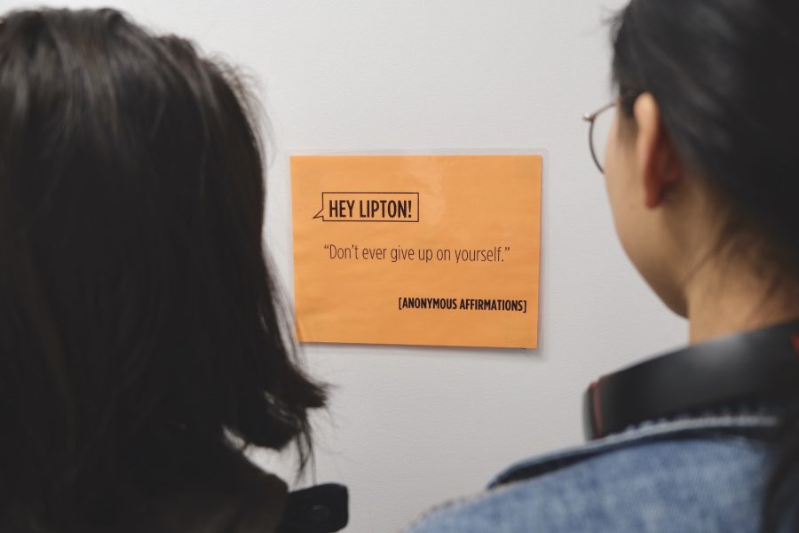 Students read Anonymous Affirmations, a Lipton Residence Hall initiative that sends messages of positivity to NYU students. (Photo by Jorene He) 