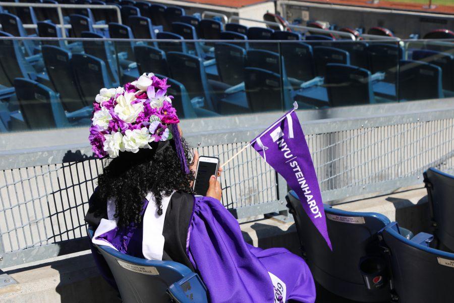 A Steinhardt graduate waits for commencement to begin. Like other graduates, she has decorated her cap with flowers. (Photo by Julia McNeill)