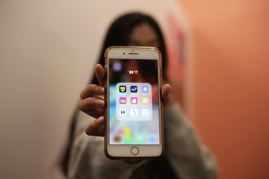 A student holds their phone, with dating apps displayed on the screen. (Staff Photo by Marva Shi)