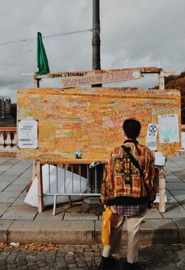 A passerby reads the Expression Libre (free expression), a bulletin board of the notes of inspiration or agenda written by protesters throughout the week.