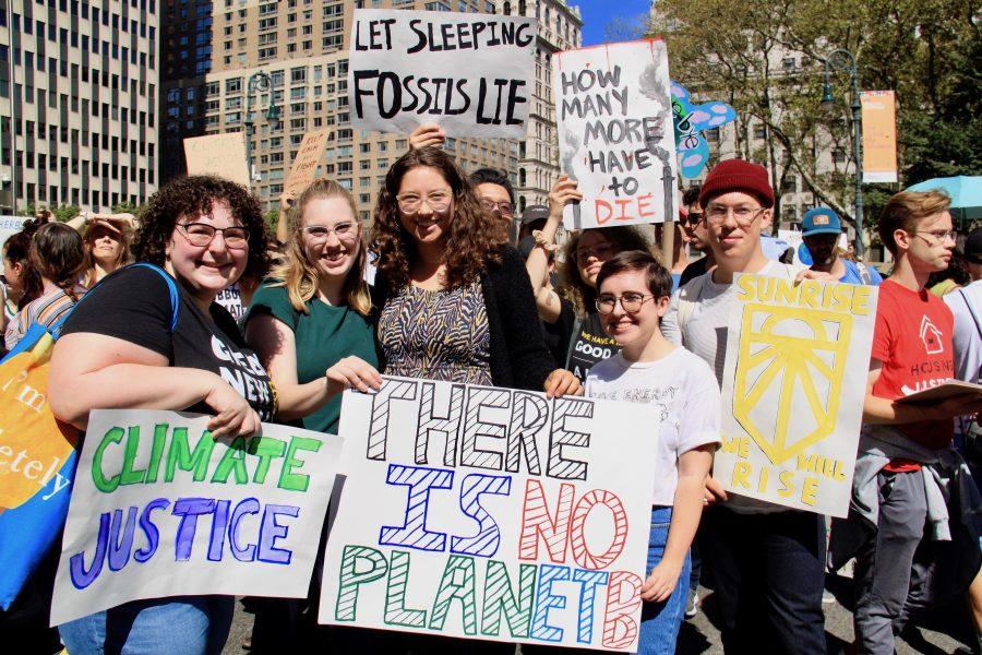 NYU students pose with their posters at Foley Square at a climate strike. NYU researchers point out the benefits of a higher carbon emission tax for the environment. (Photo by Alexandra Chan)