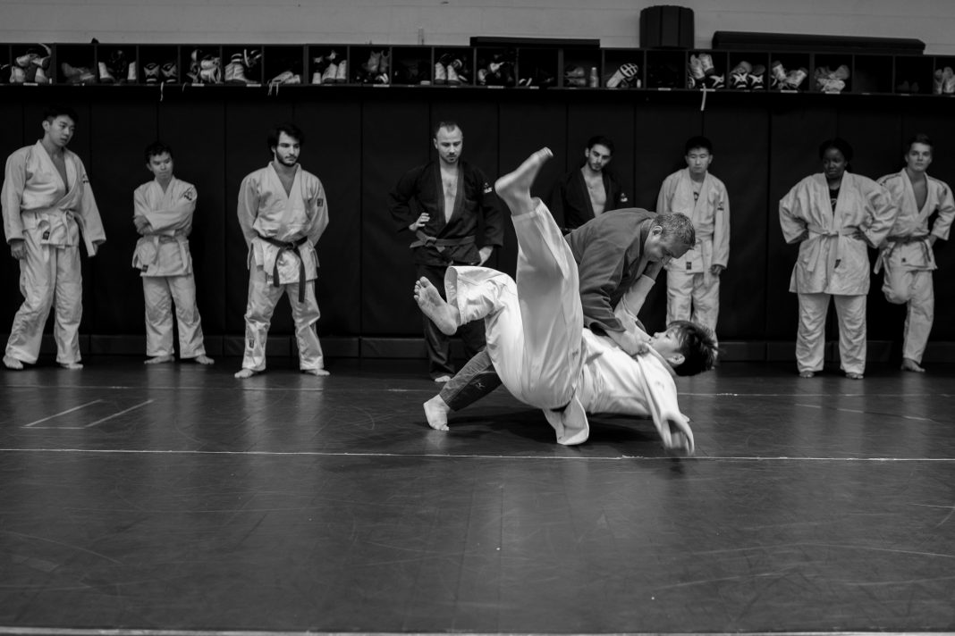 Instructor demonstrates in front of the club in the wrestling room in palladium