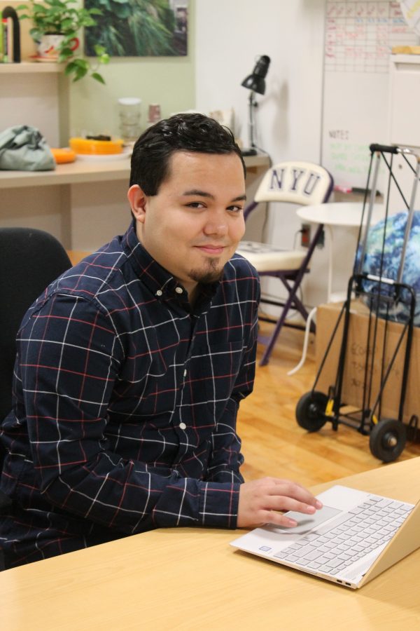 Wayne Carino works in the shared workspace at the Office of Sustainability. Carino is the only NYU Sustainability Fellow who works there. (Photo by Ellie Ballou)