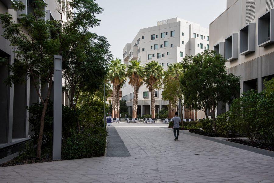 A student walks through NYU Abu Dhabis campus. NYUAD is the last of NYUs campuses to remain open amid the outbreak of the coronavirus. (Photo by Sam Klein)