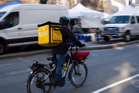 A food delivery bike speeds down a Manhattan street. The New York City Council is considering regulatings food delivery apps such as GrubHub and Postmates. (Photo by Richard Chen)
