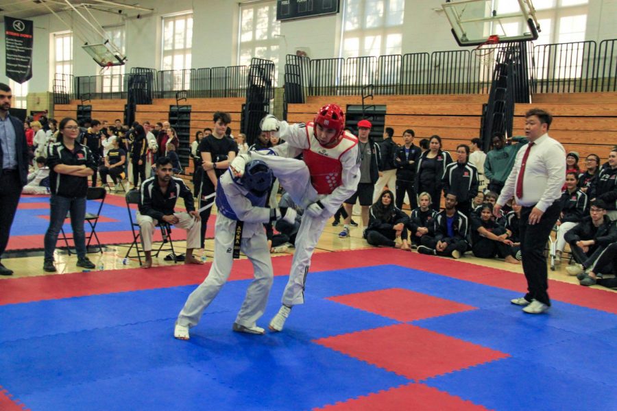 Tandon junior and NYU Taekwondo team captain Jonathan Ahn sparring in red gear scores three points with a headshot against a Rutgers opponent at the Princeton tournament in March. (Staff Photo by Alexandra Chan)