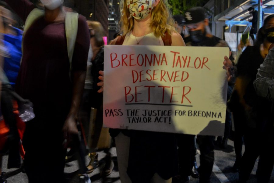A protester holds a sign reading 