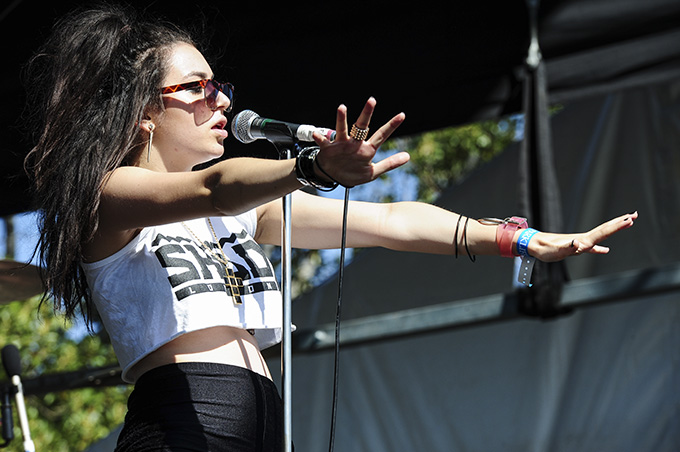 Charli XCX is an English singer and songwriter, focusing on pop music. She actively engages with her fans and uplifts queer voices, while creating pop hits. (Image via Wikimedia Commons, Stuart Sevastos)