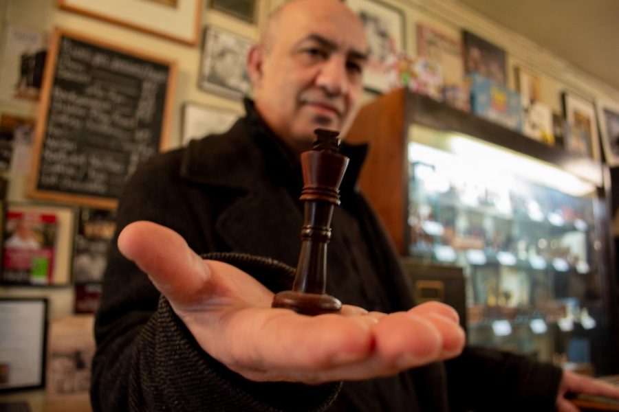 Imad Khachan presents a chess piece to the camera. Khachan owns Chess Forum in Greenwich Village on Thompson. (Staff Photo by Manasa Gudavalli)