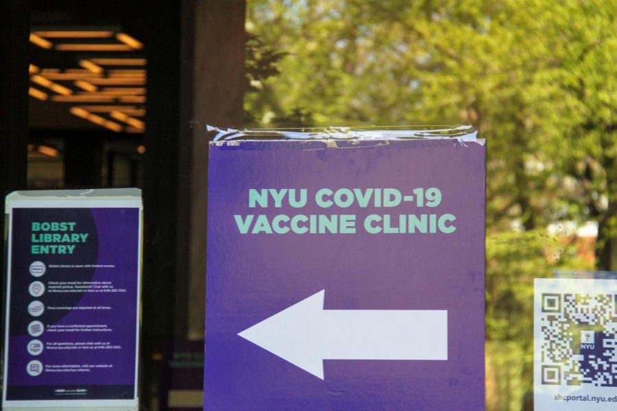 Signs directing students towards an NYU vaccine clinic decorate the front of Bobst Library. NYU students picked for the vaccine lottery gladly collect their doses.  (Staff Photo by Alexandra Chan)