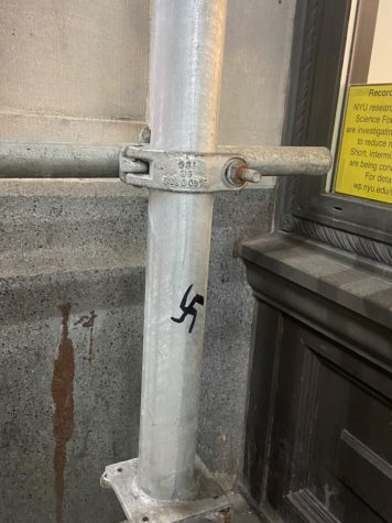 A black swastika drawn on metal scaffolding.