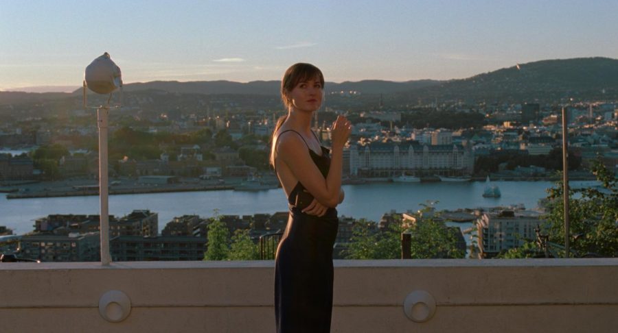 Actress Renate Reinsve from the film “The Worst Person in the World” stands on a balcony overlooking Oslo. She holds a cigarette.