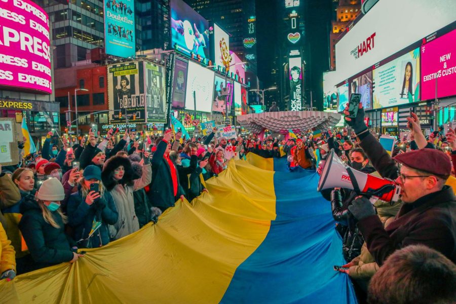 A group of protesters gathered in Times Square and held a large Ukrainian flag between them.