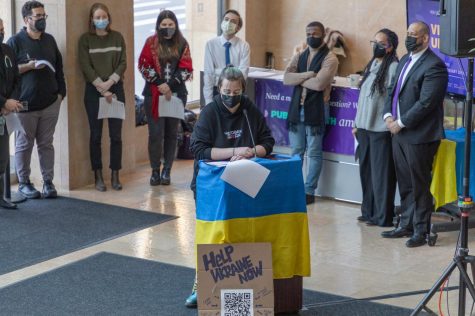 A supporter speaks to a crowd of NYU and Ukrainian community members that is gathered in the entrance lobby of the Kimmel Center for University Life during NYU's Vigil for Ukraine.