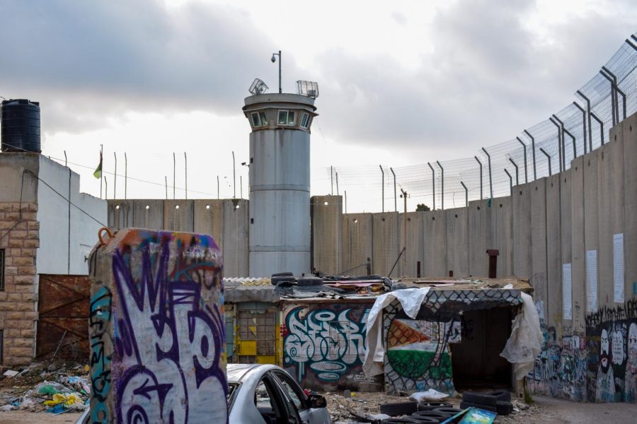 A+concrete+guard+tower+overlooks+rubble+and+trash+lying+in+the+shadow+of+the+tall%2C+concrete+Israeli+West+Bank+separation+barrier%2C+which+is+covered+in+graffiti.